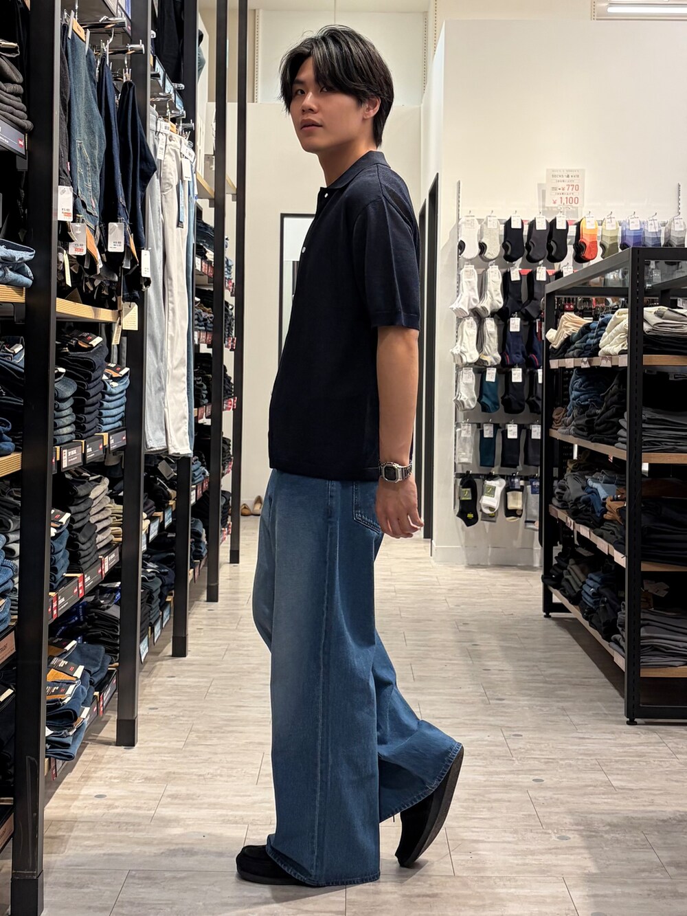 ブルー系のデニムパンツ、ブルー系のニット/セーター、ブラウン系のベルトを着用したメンズの夏コーディネートの4枚目の写真