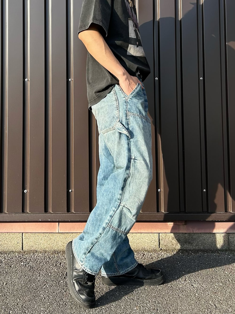 ブラック系のTシャツ/カットソー、ブルー系のデニムパンツを着用したメンズの春コーディネートの5枚目の写真