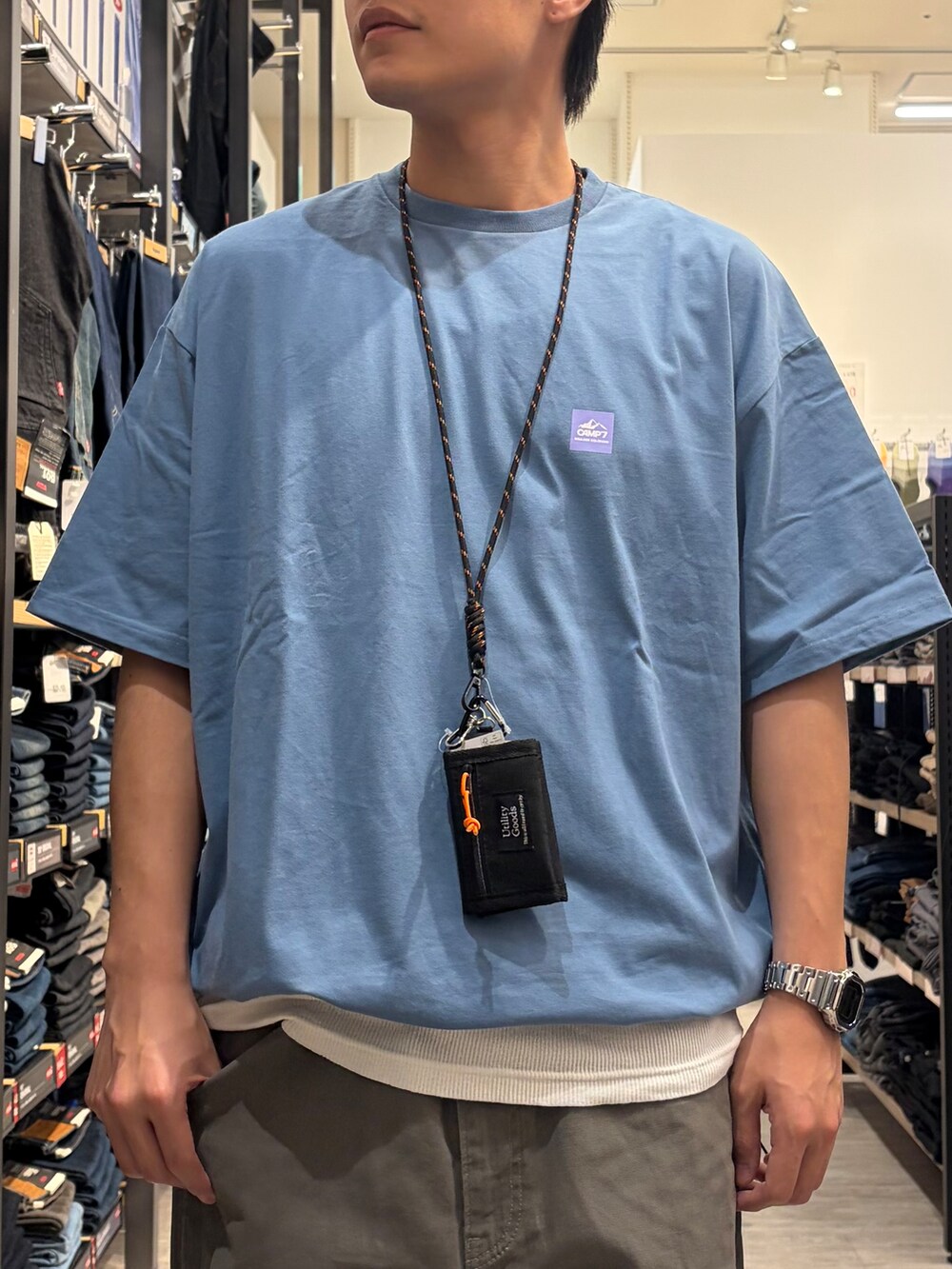 ブルー系のTシャツ/カットソー、グリーン系のデニムパンツ、ブラック系のショルダーバッグを着用したメンズの夏コーディネートの5枚目の写真