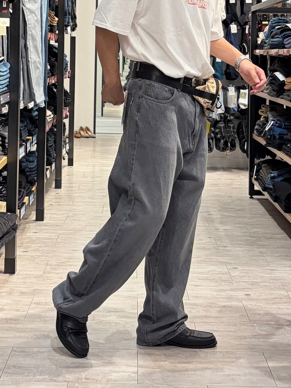 ブラック系のデニムパンツ、ホワイト系のTシャツ/カットソー、ベージュ系のボディバッグ/ウエストポーチを着用したメンズの夏コーディネートの9枚目の写真