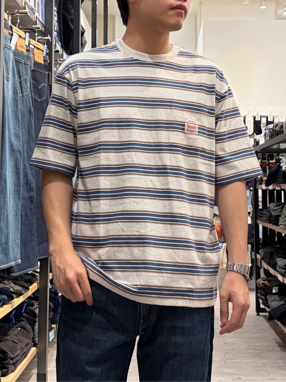 ブラウン系のシャツ/ブラウス、ホワイト系のTシャツ/カットソー、ブルー系のデニムパンツを着用したメンズの春コーディネートの9枚目の写真