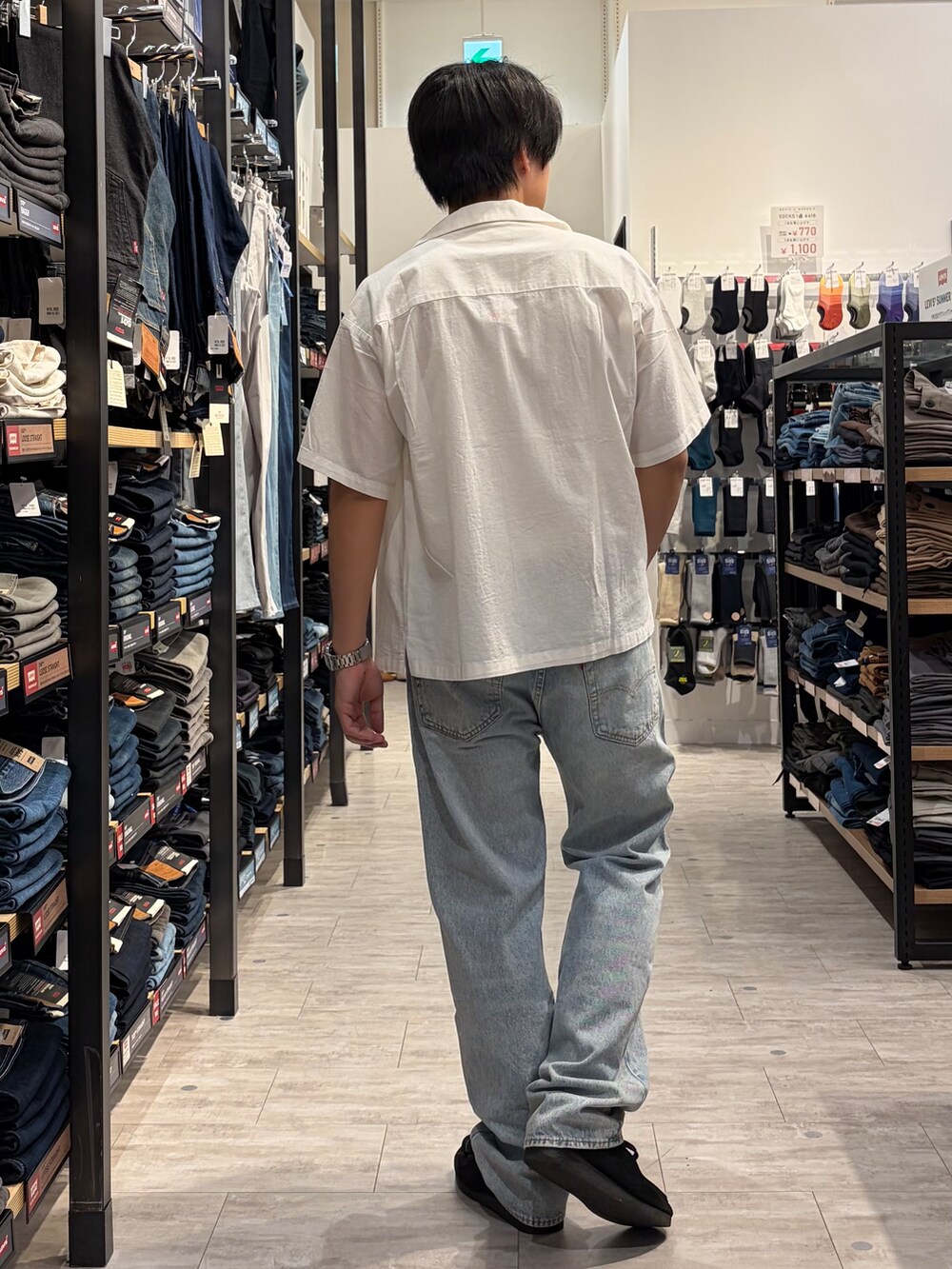 ブルー系のデニムパンツ、ホワイト系のシャツ/ブラウス、ブラウン系のベルトを着用したメンズの春コーディネートの3枚目の写真