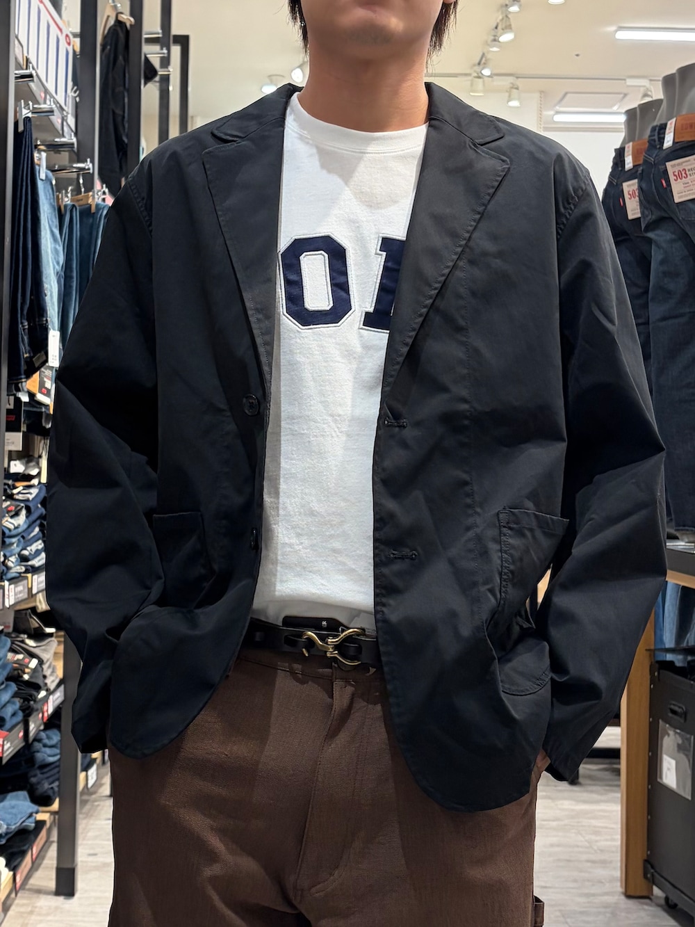 ホワイト系のTシャツ/カットソー、ブラウン系のその他パンツ、ブラック系のテーラードジャケットを着用したメンズの夏コーディネートの6枚目の写真