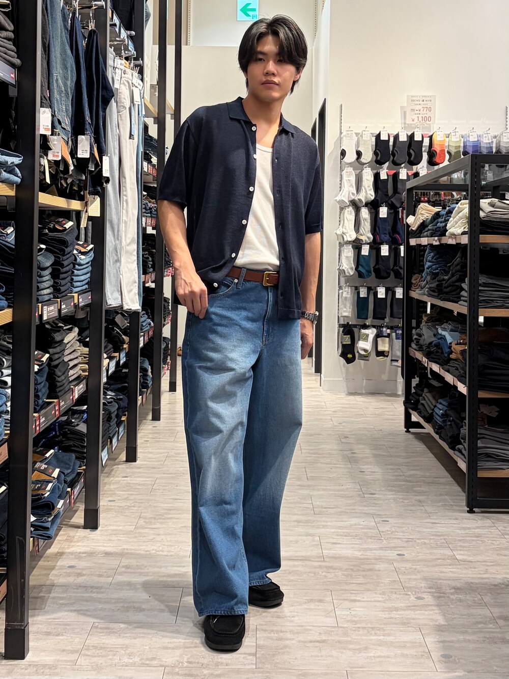 ブルー系のデニムパンツ、ブルー系のニット/セーター、ブラウン系のベルトを着用したメンズの夏コーディネートの2枚目の写真