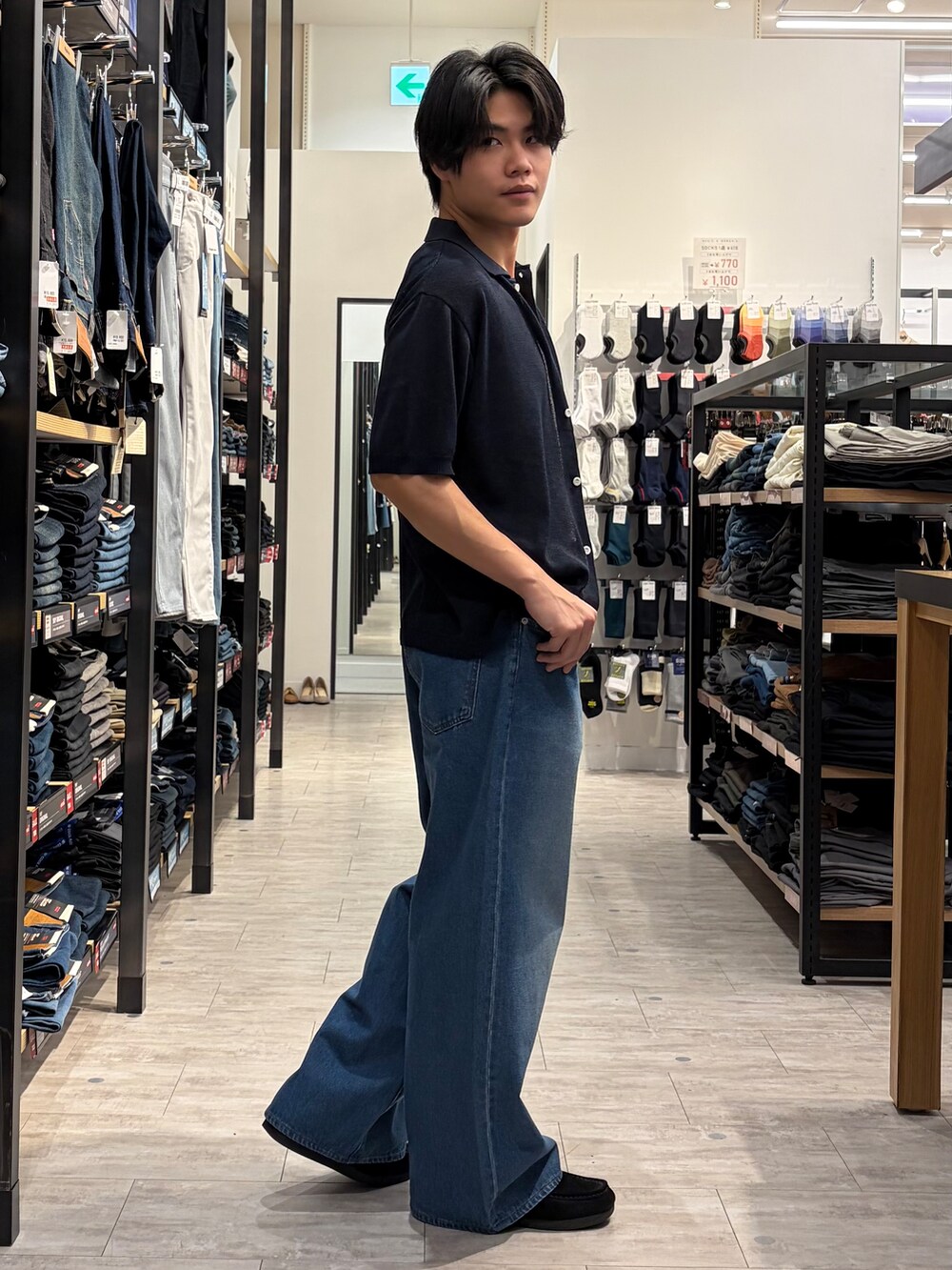 ブルー系のデニムパンツ、ブルー系のニット/セーター、ブラウン系のベルトを着用したメンズの夏コーディネートの3枚目の写真