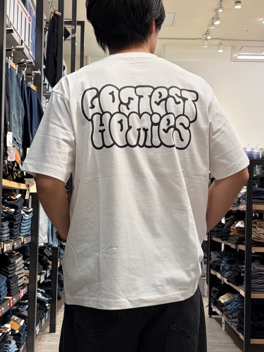 ホワイト系のTシャツ/カットソー、ブラック系のデニムパンツ、ブラック系のベルトを着用したメンズの夏コーディネートの7枚目の写真