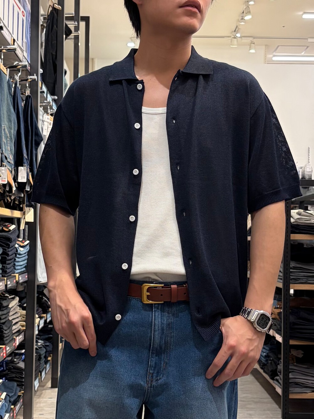 ブルー系のデニムパンツ、ブルー系のニット/セーター、ブラウン系のベルトを着用したメンズの夏コーディネートの6枚目の写真