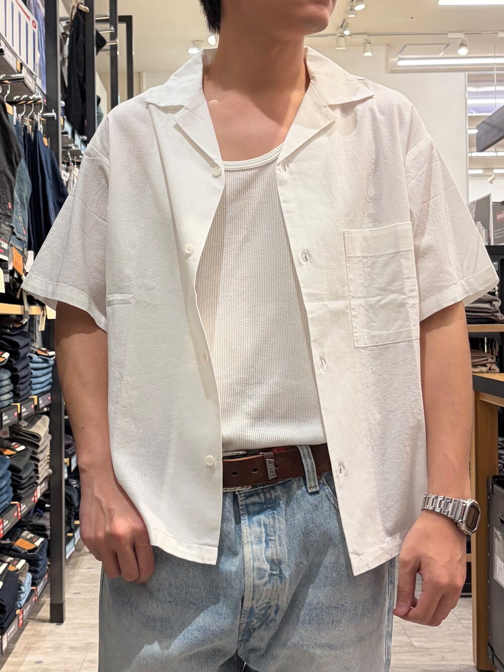 ブルー系のデニムパンツ、ホワイト系のシャツ/ブラウス、ブラウン系のベルトを着用したメンズの春コーディネートの4枚目の写真