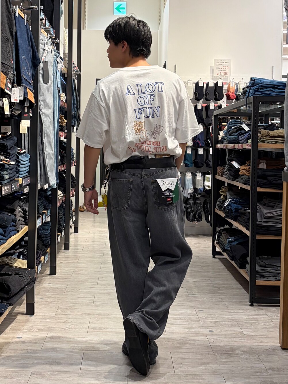 ブラック系のデニムパンツ、ホワイト系のTシャツ/カットソー、ベージュ系のボディバッグ/ウエストポーチを着用したメンズの夏コーディネートの2枚目の写真