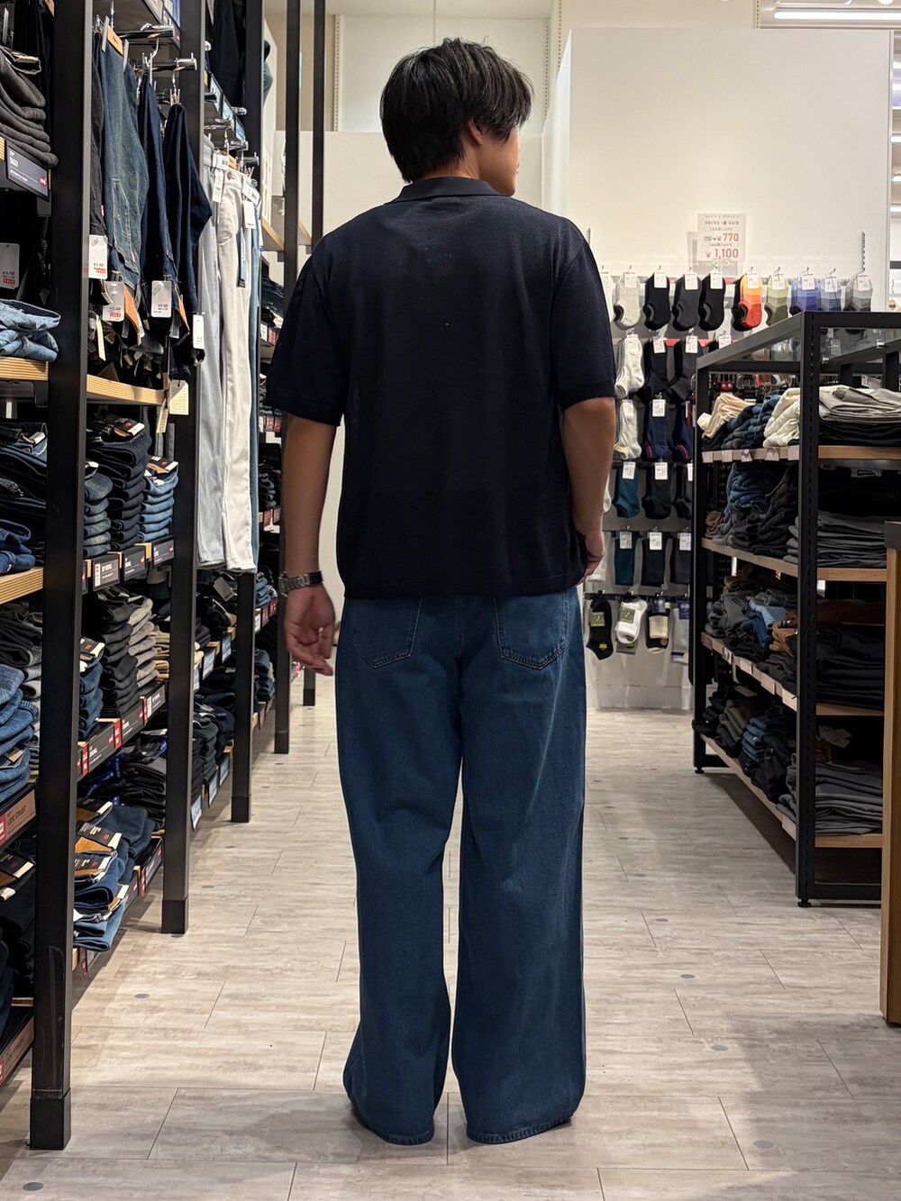 ブルー系のデニムパンツ、ブルー系のニット/セーター、ブラウン系のベルトを着用したメンズの夏コーディネートの5枚目の写真