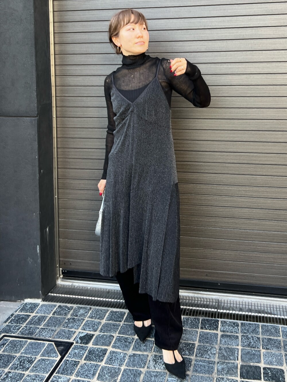 ブラック系のワンピース、ブラック系のニット/セーター、シルバー系のショルダーバッグを着用したレディースの秋コーディネートの2枚目の写真