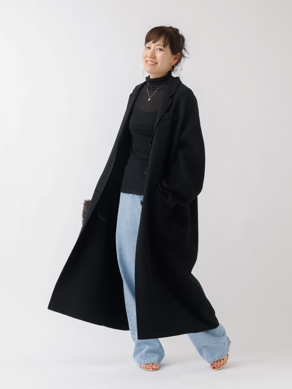 ブラック系のチェスターコート、ブラック系のTシャツ/カットソー、ブルー系のデニムパンツを着用したレディースの夏コーディネートの2枚目の写真