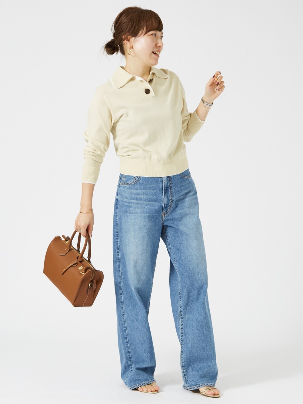 ブルー系のデニムパンツ、イエロー系のショルダーバッグ、ベージュ系のニット/セーターを着用したレディースの春コーディネートの2枚目の写真