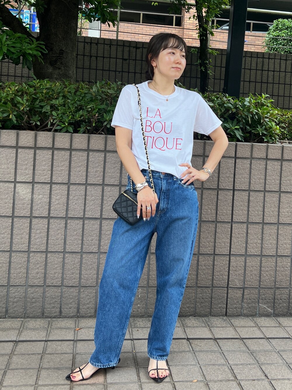 ホワイト系のTシャツ/カットソー、ブルー系のデニムパンツ、ブラック系のショルダーバッグを着用したレディースの夏コーディネートの3枚目の写真