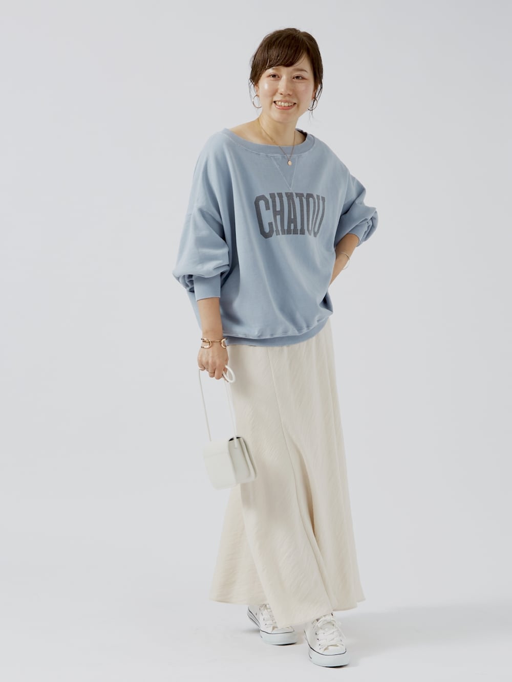 ブルー系のスウェット、ホワイト系のショルダーバッグを着用したレディースの夏コーディネートの2枚目の写真