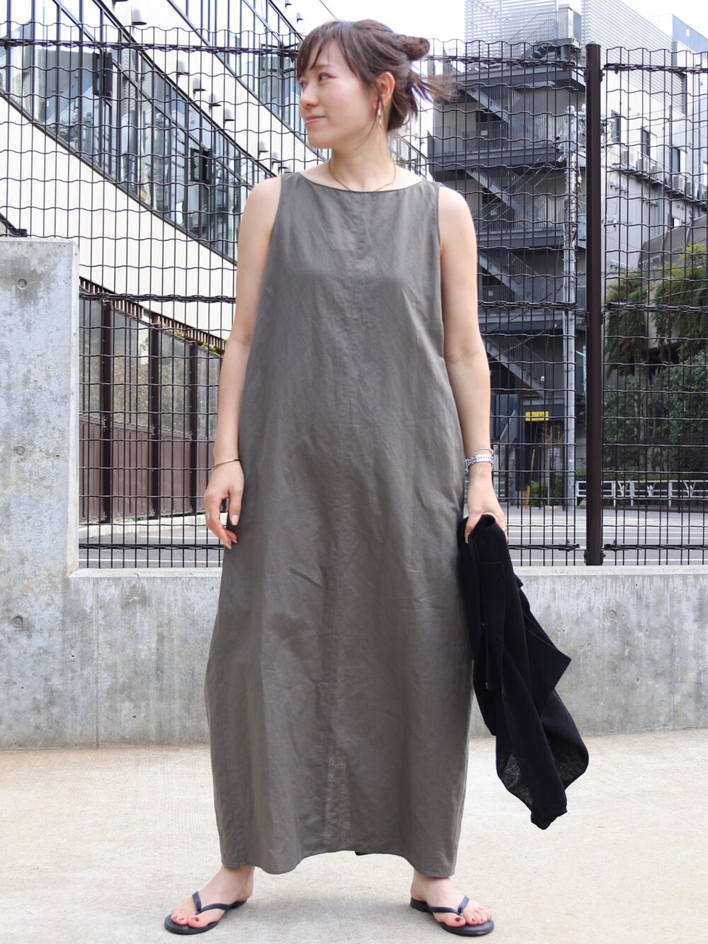 ベージュ系のワンピース、ブラック系のカーディガン/ボレロを着用したレディースの夏コーディネートの2枚目の写真