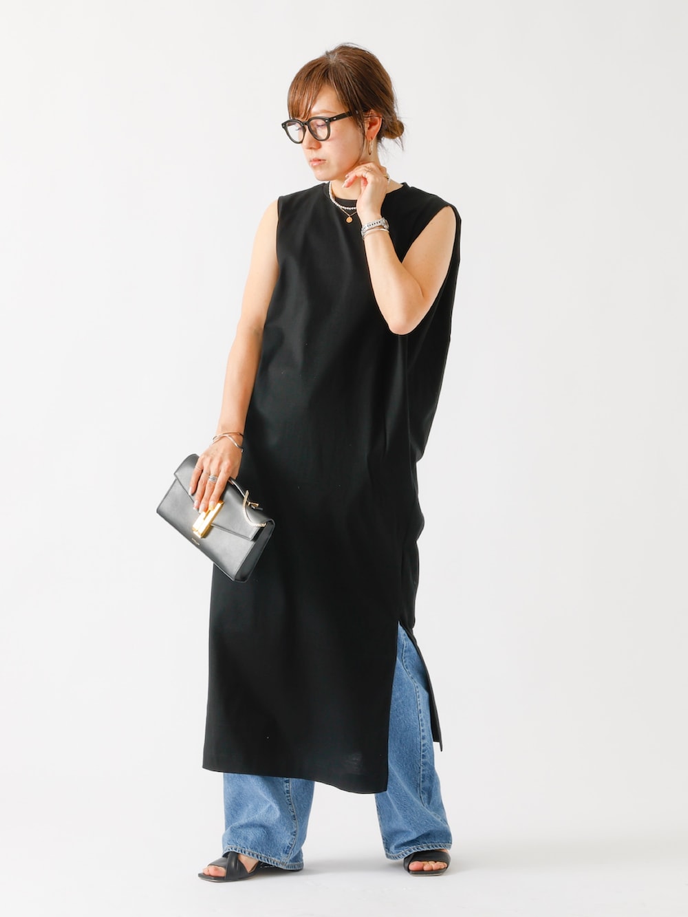 ブルー系のデニムパンツ、ブラック系のショルダーバッグを着用したレディースの春コーディネートの2枚目の写真