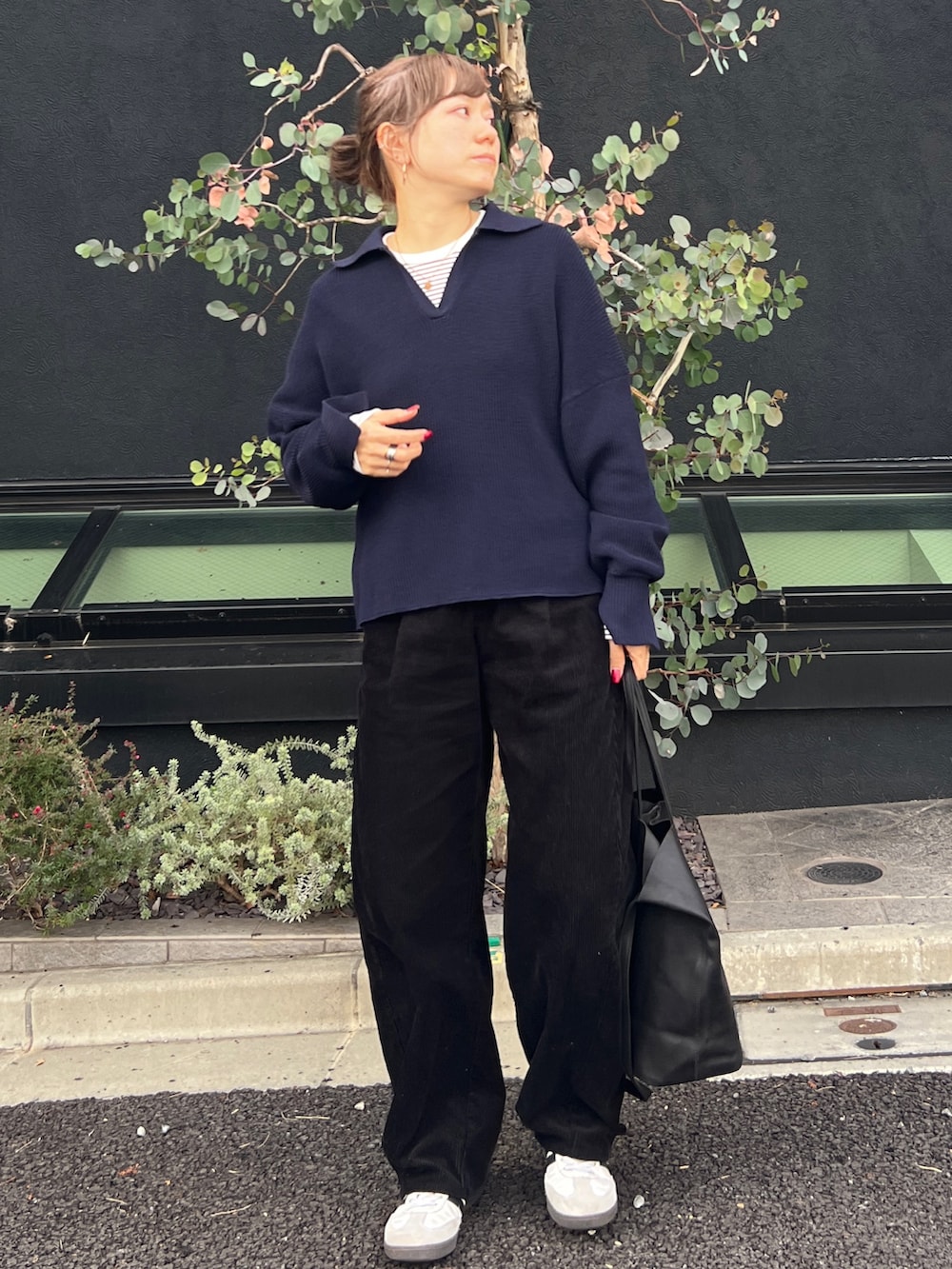 ブルー系のニット/セーター、ホワイト系のスニーカー、ブラック系のトートバッグを着用したレディースの冬コーディネートの2枚目の写真