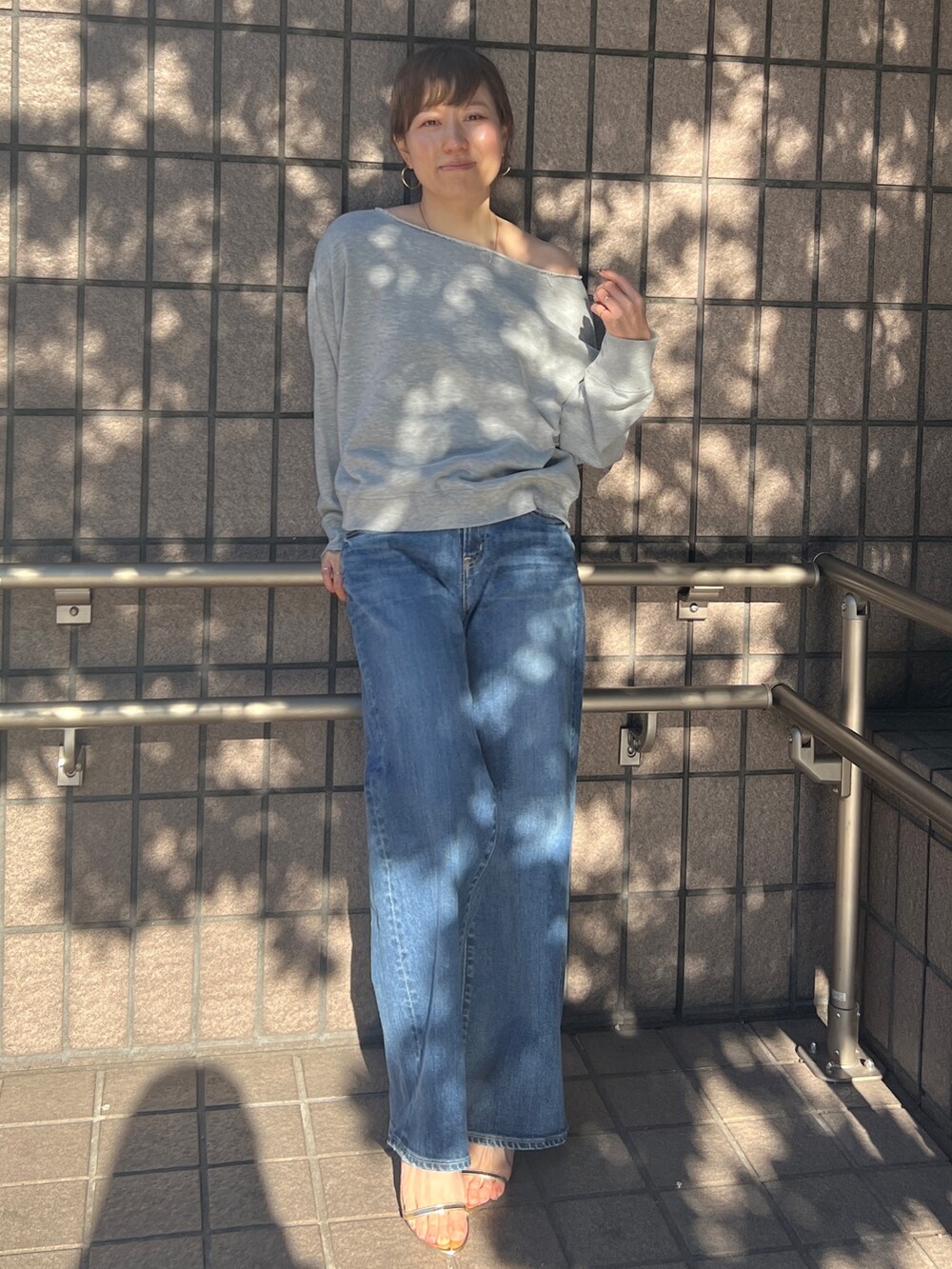 グレー系のTシャツ/カットソー、ブルー系のデニムパンツを着用したレディースの冬コーディネートの2枚目の写真