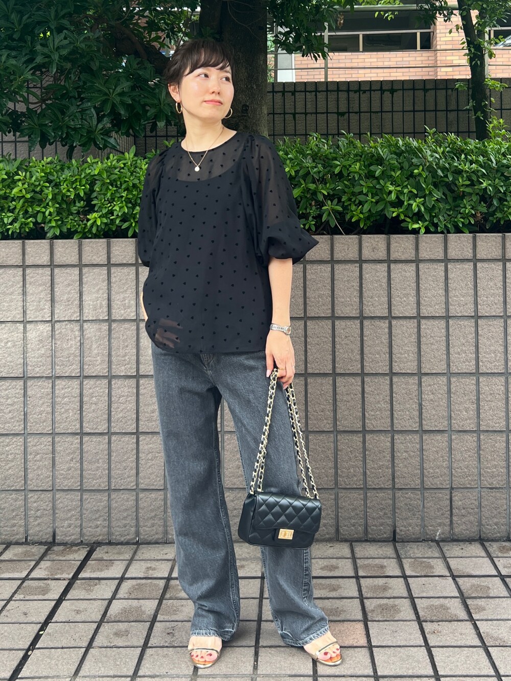 ブラック系のシャツ/ブラウス、ブラック系のショルダーバッグ、ブラック系のデニムパンツを着用したレディースの夏コーディネートの2枚目の写真