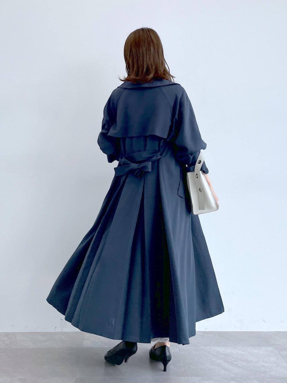 ブルー系のトレンチコート、グレー系のニット/セーター、グレー系のスカートを着用したレディースの冬コーディネートの4枚目の写真