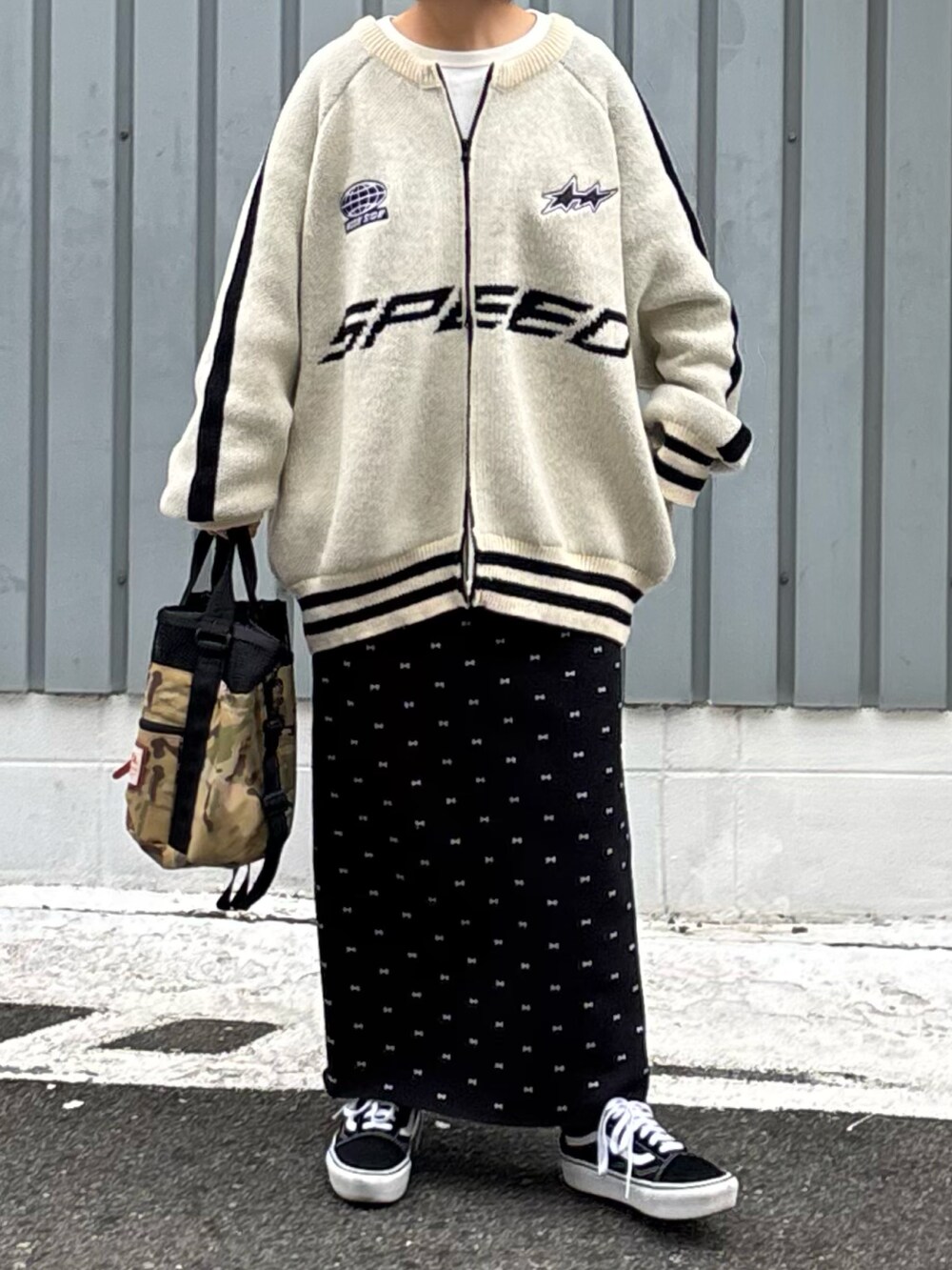 ブラック系のスカート、ブラック系のスニーカー、ホワイト系のブルゾンを着用したレディースの冬コーディネートの3枚目の写真