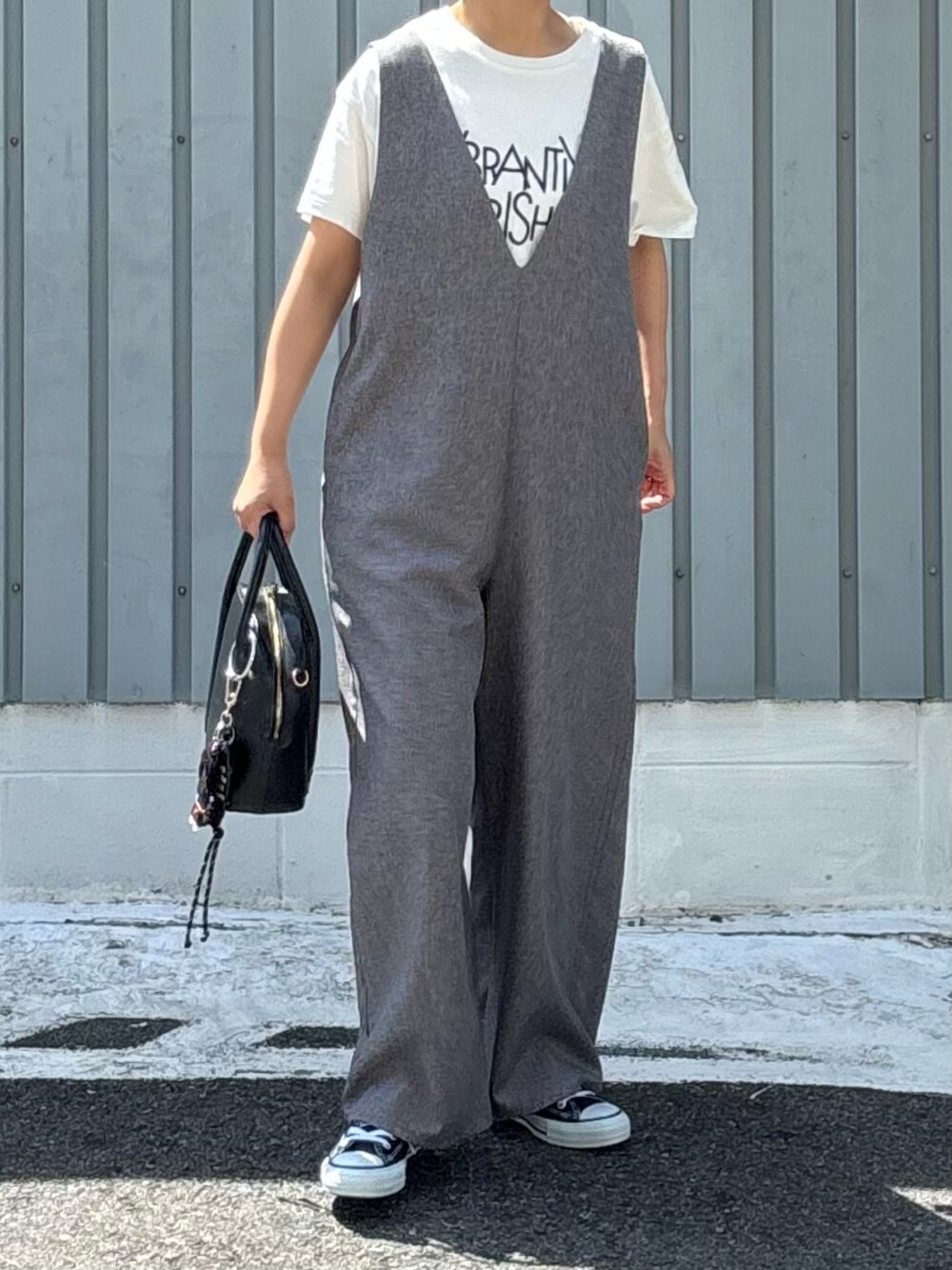 ホワイト系のTシャツ/カットソー、ブラック系のスニーカー、グレー系のサロペット/オーバーオールを着用したレディースの夏コーディネートの2枚目の写真