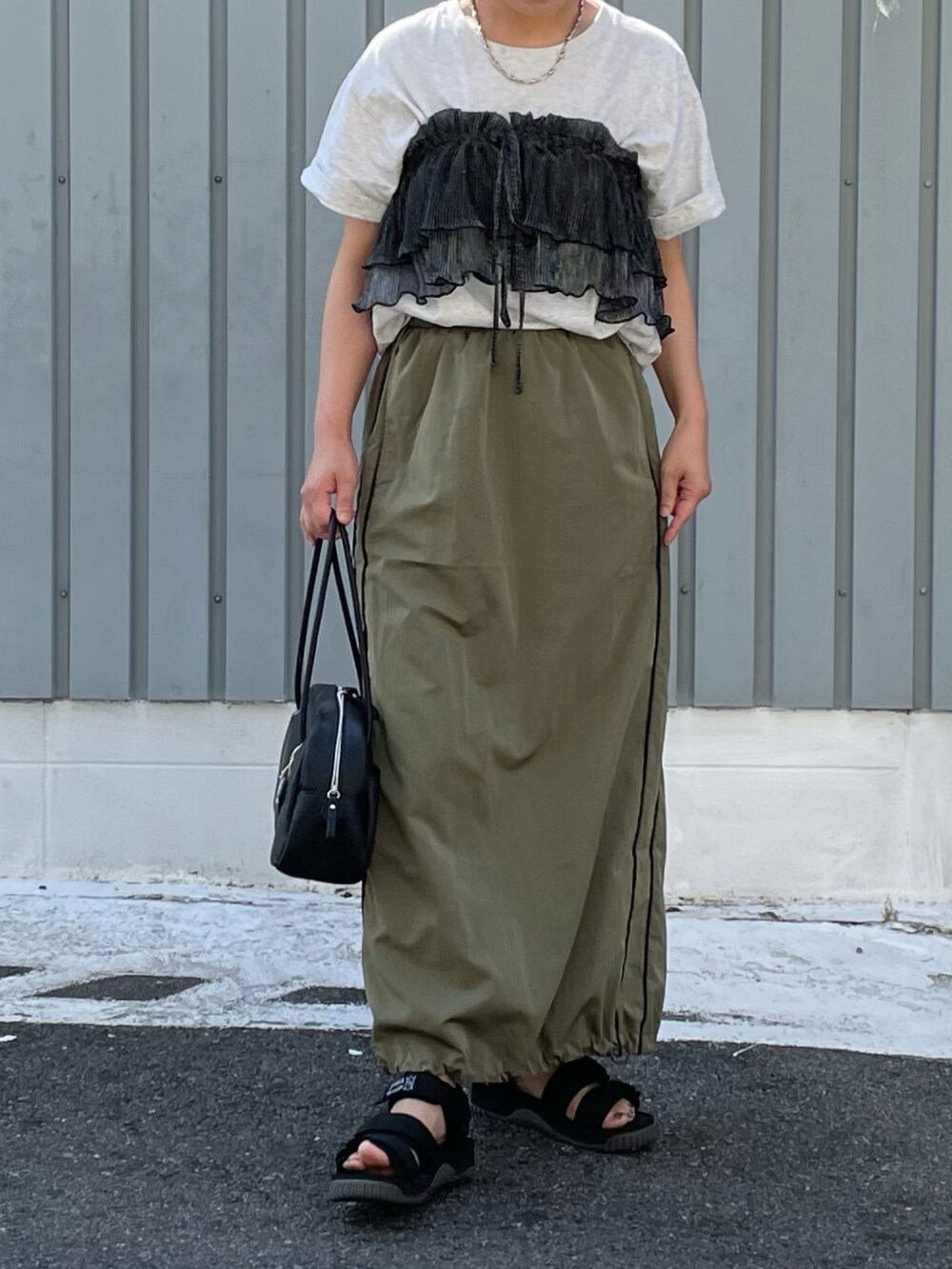 ブラック系のサンダル、グリーン系のスカート、グレー系のTシャツ/カットソーを着用したレディースの夏コーディネートの2枚目の写真