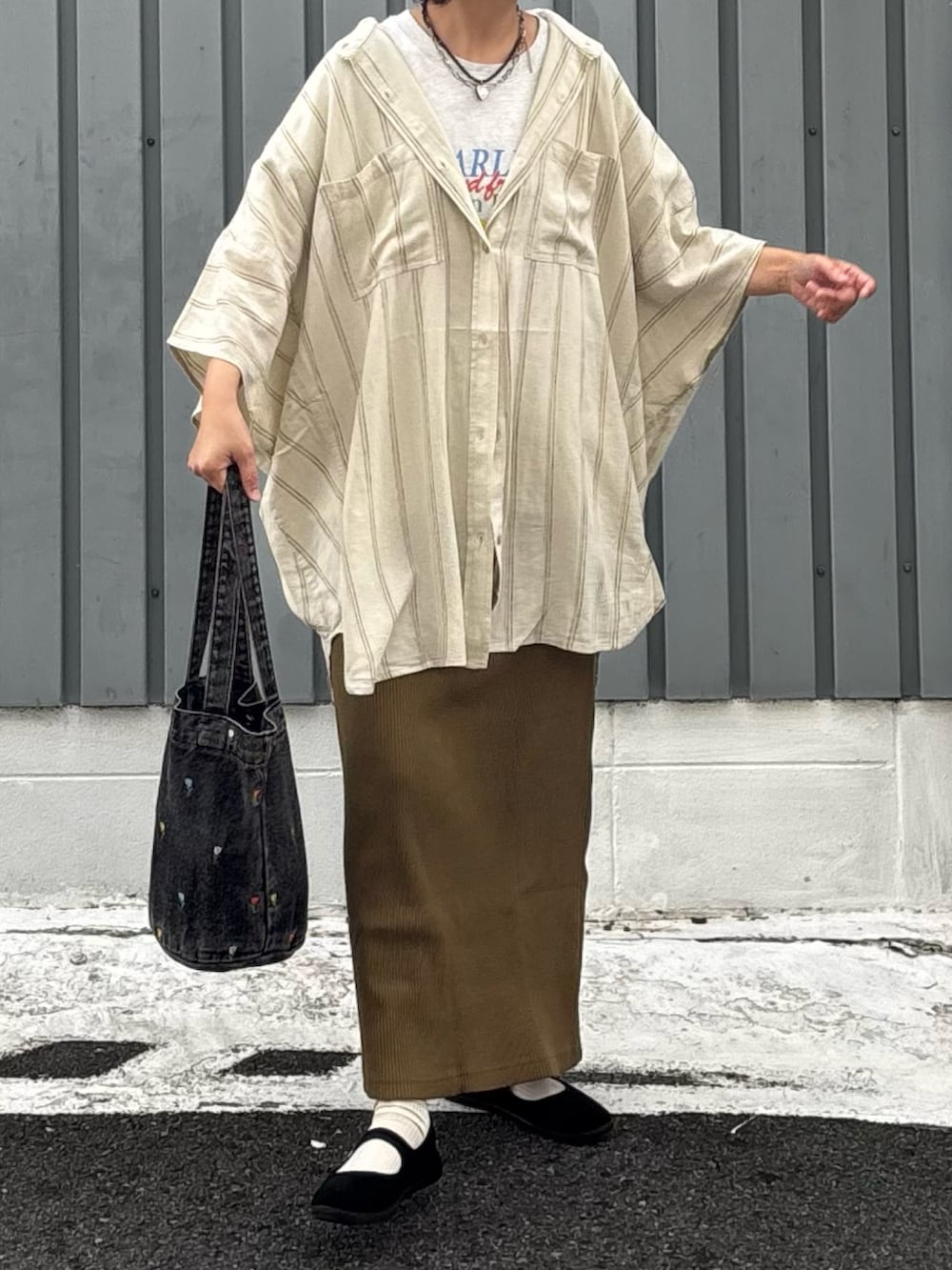 グリーン系のスカート、ブラウン系のシャツ/ブラウス、ベージュ系のTシャツ/カットソーを着用したレディースの秋コーディネートの2枚目の写真
