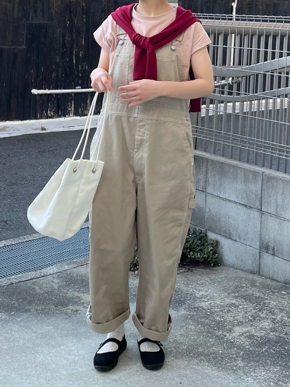 ホワイト系のショルダーバッグ、ブラック系のバレエシューズ、ピンク系のTシャツ/カットソーを着用したレディースの夏コーディネートの2枚目の写真