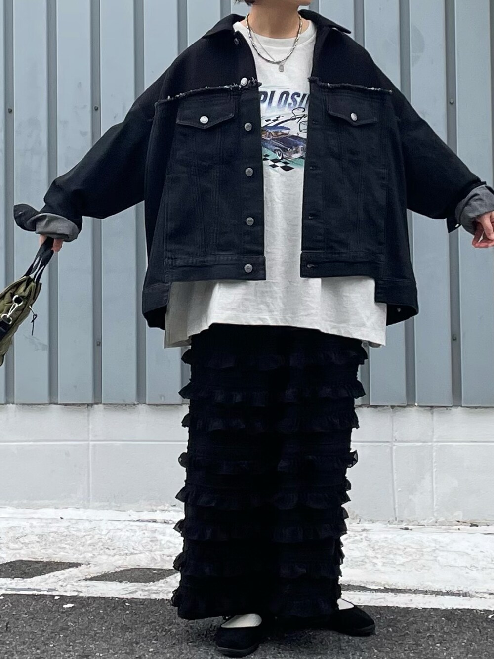 ブラック系のスカート、ベージュ系のTシャツ/カットソー、ブラック系のデニムジャケットを着用したレディースの秋コーディネートの3枚目の写真