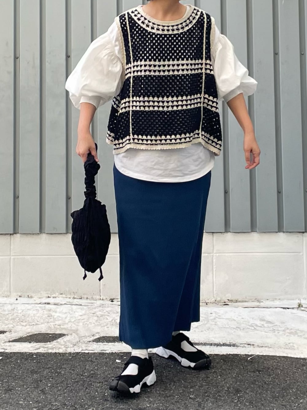 ブルー系のスカート、ブラック系のスニーカー、ホワイト系のシャツ/ブラウスを着用したレディースの夏コーディネートの2枚目の写真