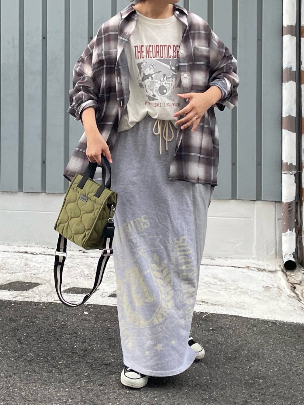 グリーン系のショルダーバッグ、グレー系のスカート、ホワイト系のTシャツ/カットソーを着用したレディースの夏コーディネートの2枚目の写真