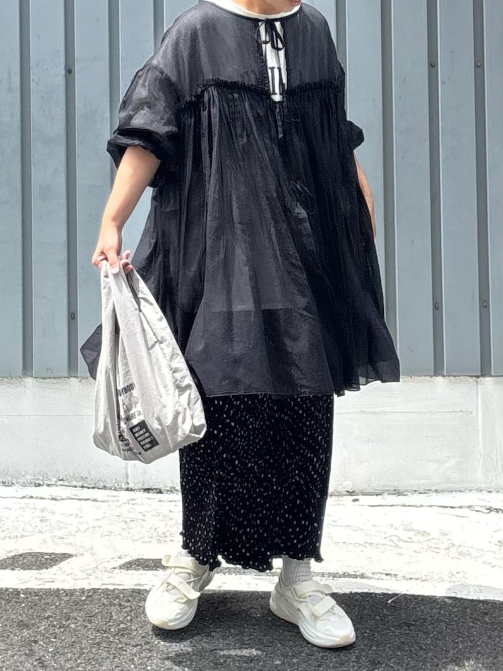 グレー系のエコバッグ/サブバッグ、ブラック系のワンピース、ホワイト系のサンダルを着用したレディースの春コーディネートの2枚目の写真