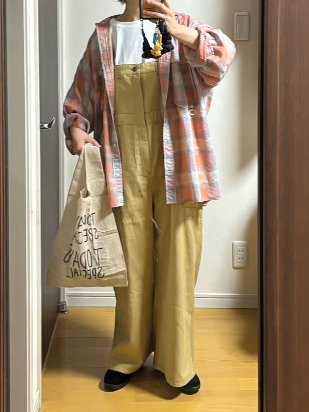 ベージュ系のオールインワン・サロペット、オレンジ系のシャツ/ブラウスを着用したレディースの春コーディネートの2枚目の写真