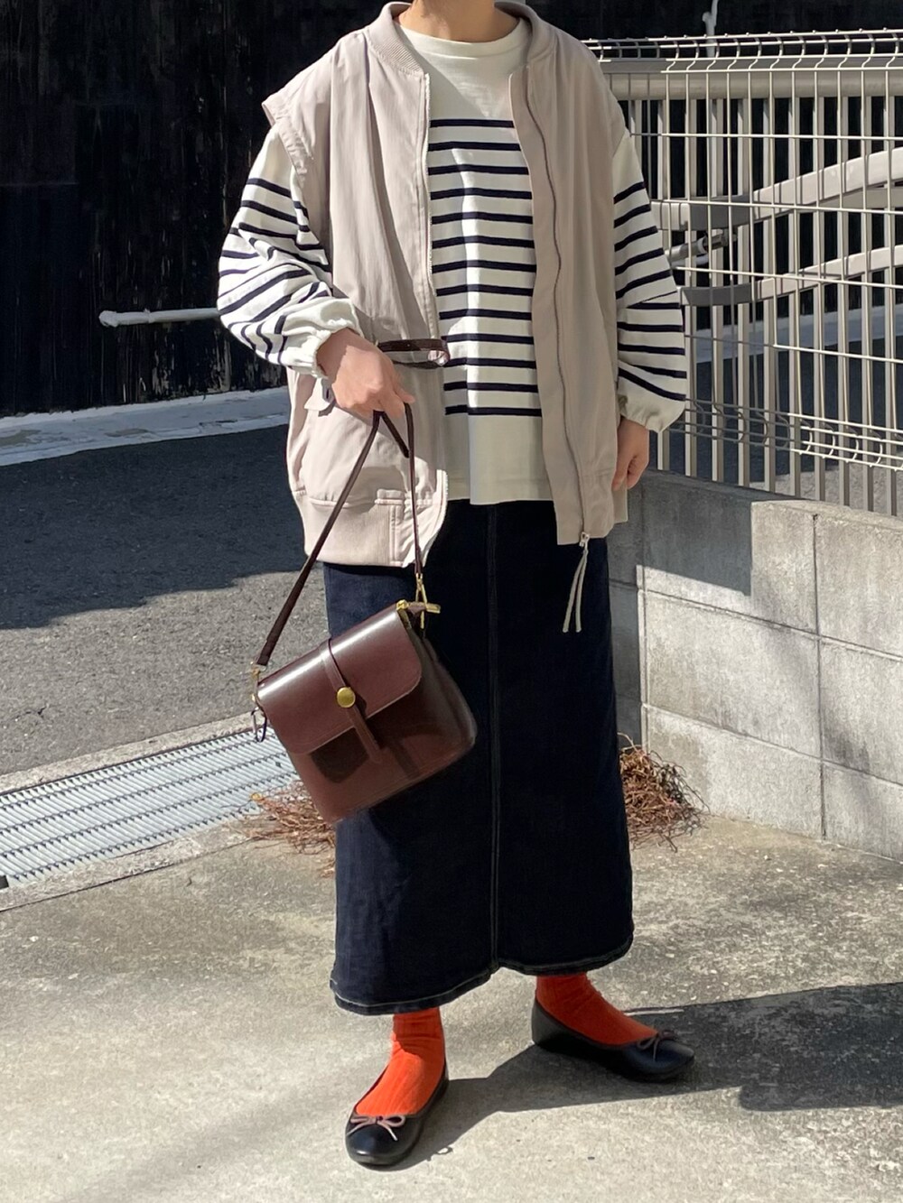 ブラウン系のショルダーバッグ、ブルー系のTシャツ/カットソー、ブルー系のデニムスカートを着用したレディースの春コーディネートの2枚目の写真