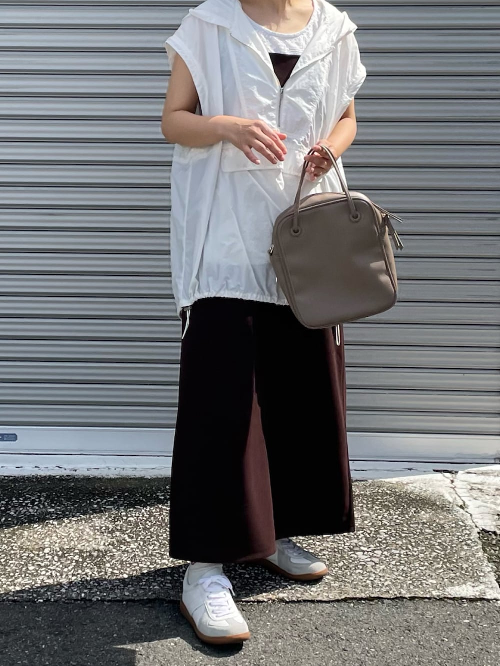 ブラウン系のワンピース、ホワイト系のパーカー、ホワイト系のスニーカーを着用したレディースの夏コーディネートの2枚目の写真