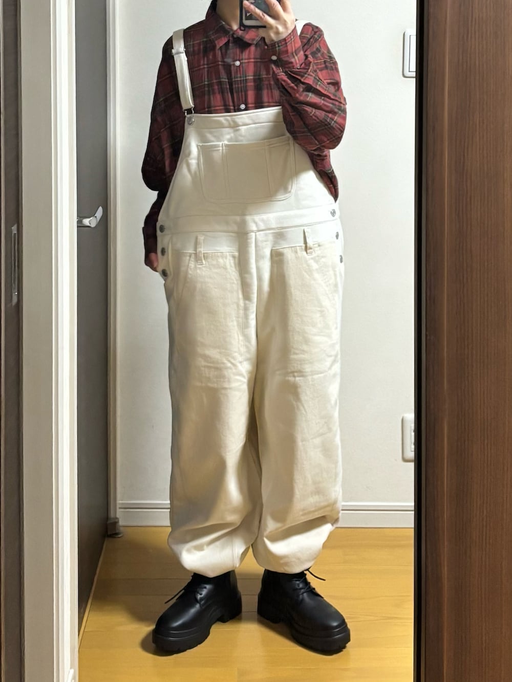 ホワイト系のオールインワン・サロペット、ベージュ系のベスト、レッド系のシャツ/ブラウスを着用したレディースの冬コーディネートの3枚目の写真