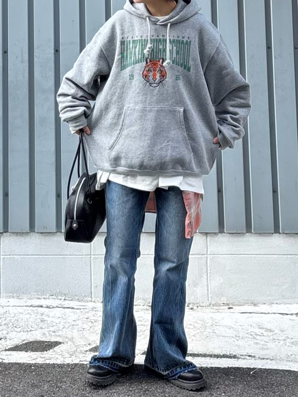 グレー系のパーカー、ブラック系のブーツ、ブルー系のデニムパンツを着用したレディースの冬コーディネートの3枚目の写真