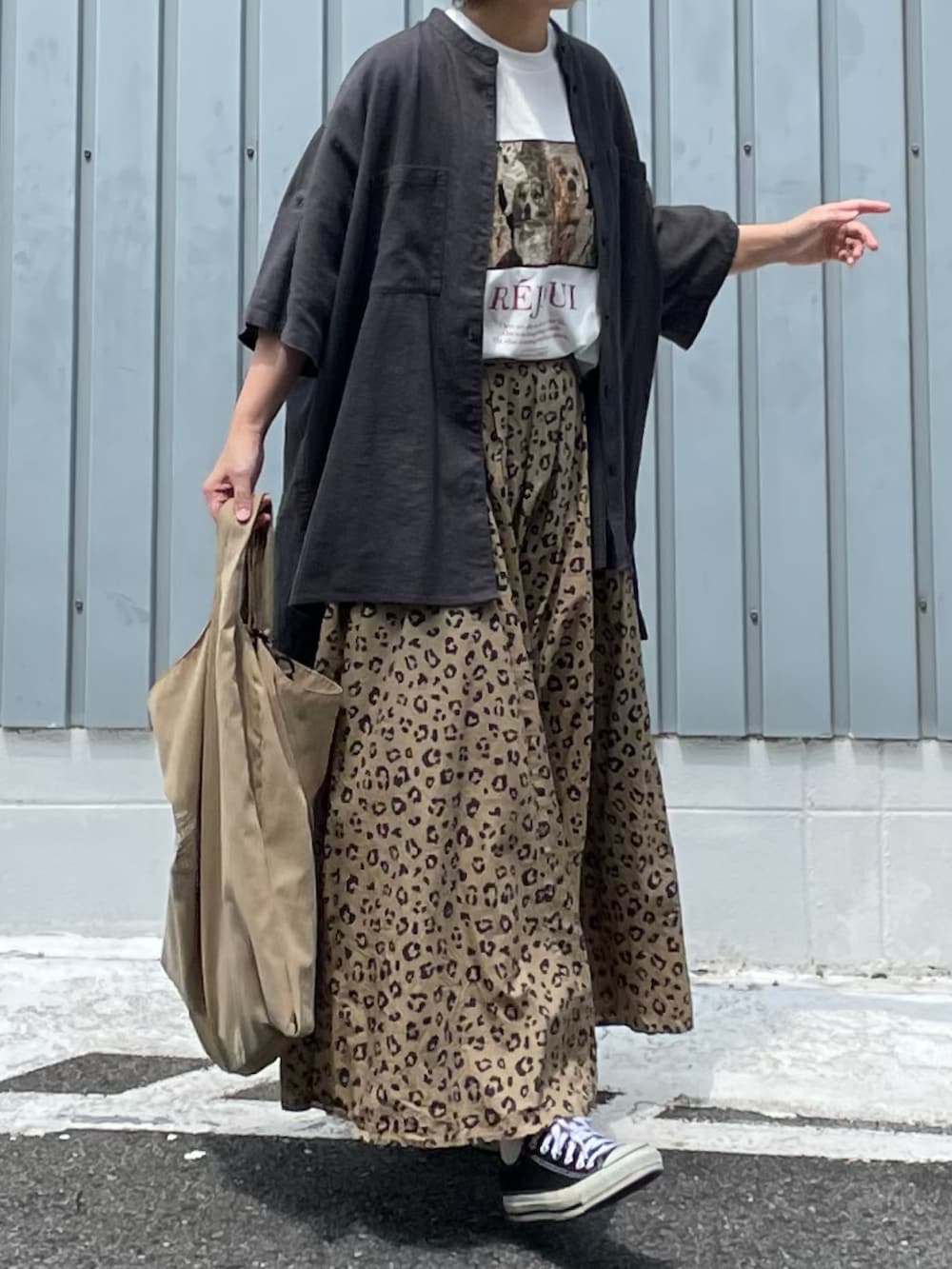 ブラック系のスニーカー、ベージュ系のスカート、ベージュ系のエコバッグ/サブバッグを着用したレディースの秋コーディネートの2枚目の写真