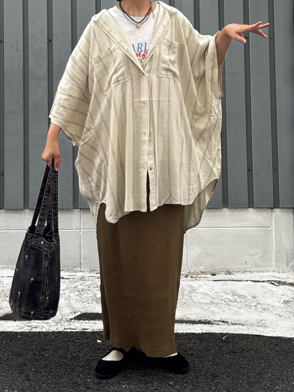 グリーン系のスカート、ブラウン系のシャツ/ブラウス、ベージュ系のTシャツ/カットソーを着用したレディースの秋コーディネートの3枚目の写真
