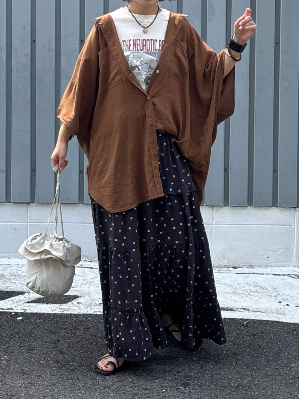 ブラウン系のスカート、ブラウン系のシャツ/ブラウス、ホワイト系のTシャツ/カットソーを着用したレディースの夏コーディネートの2枚目の写真