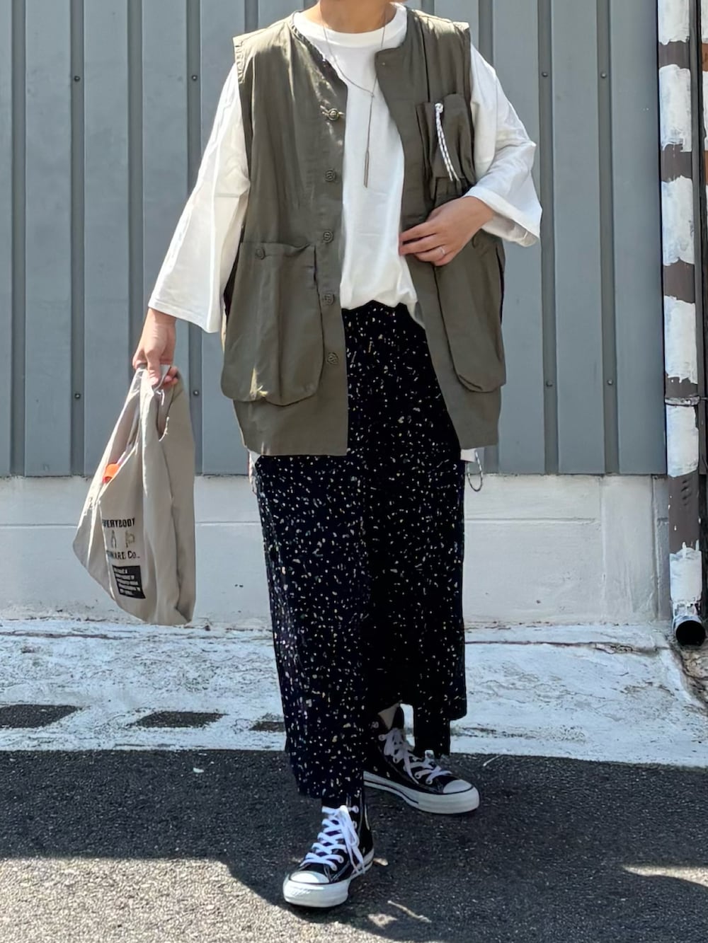 グレー系のエコバッグ/サブバッグ、ブルー系のその他パンツ、ブラック系のスニーカーを着用したレディースの夏コーディネートの2枚目の写真