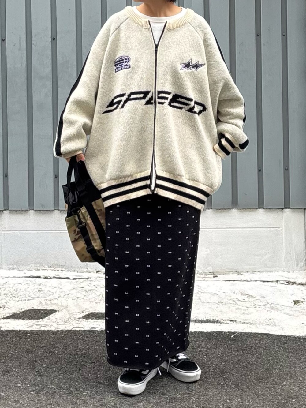 ブラック系のスカート、ブラック系のスニーカー、ホワイト系のブルゾンを着用したレディースの冬コーディネートの2枚目の写真