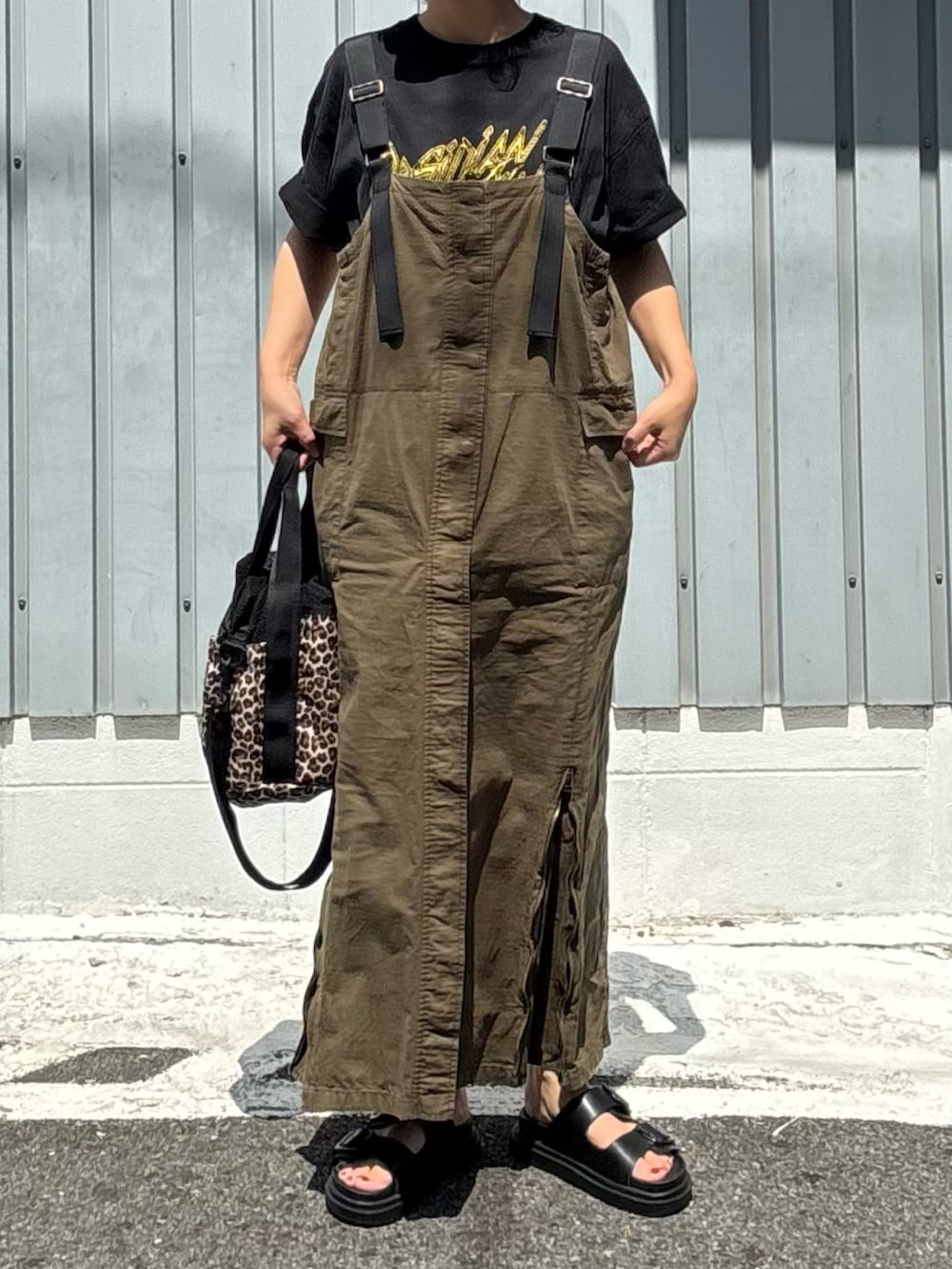 その他のショルダーバッグ、ブラック系のサンダル、グリーン系のジャンパースカートを着用したレディースの夏コーディネートの2枚目の写真