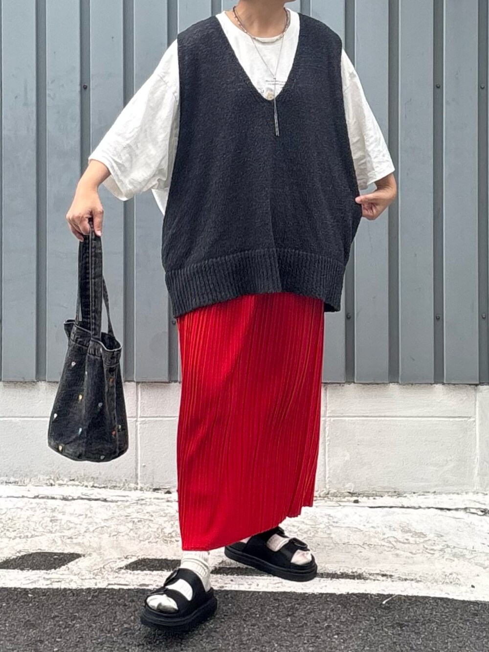 ブラック系のサンダル、レッド系のスカート、グレー系のニット/セーターを着用したレディースの夏コーディネートの2枚目の写真