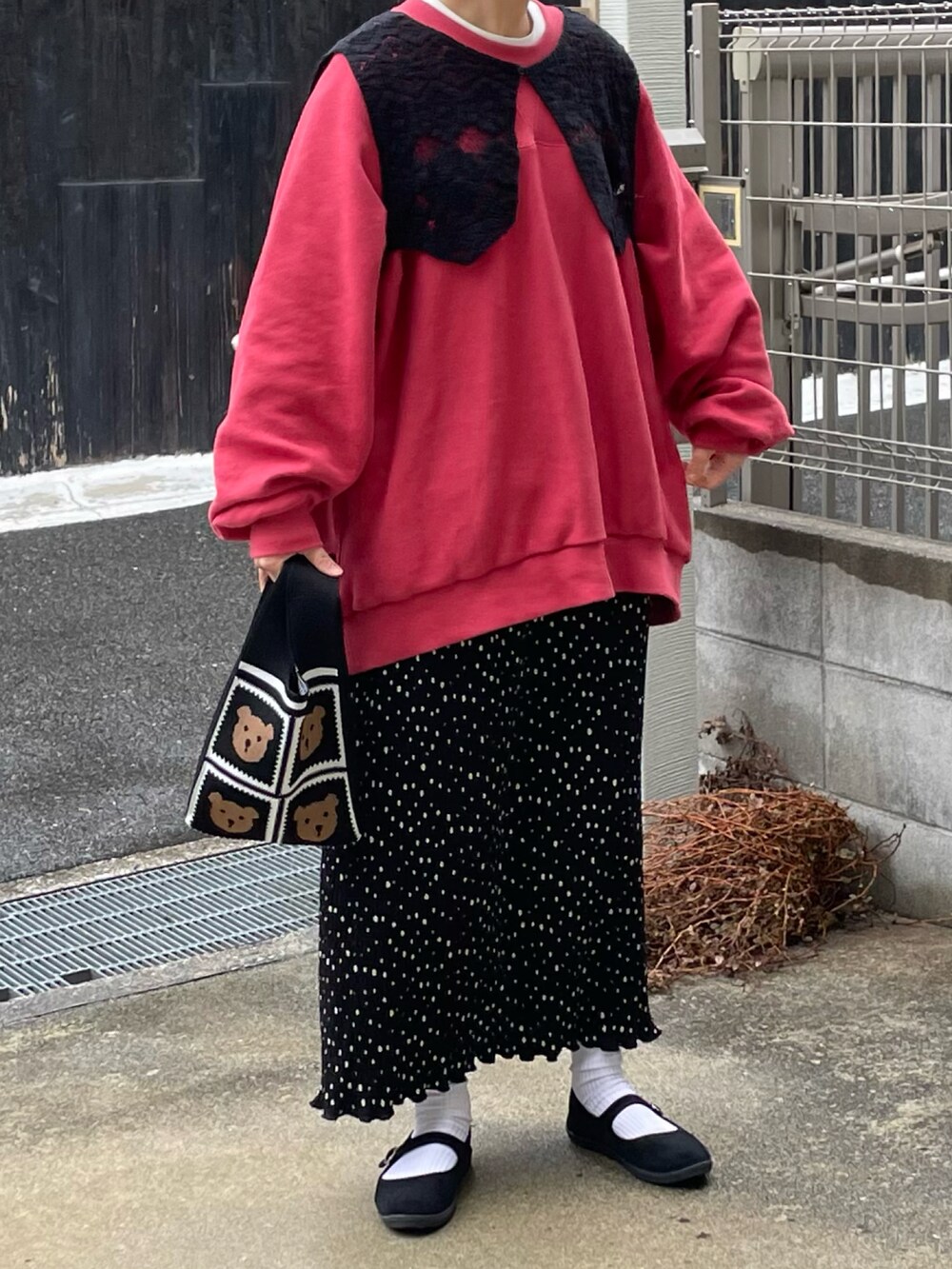 ブラック系のスカート、レッド系のTシャツ/カットソー、ブラック系のバッグを着用したレディースの冬コーディネートの2枚目の写真