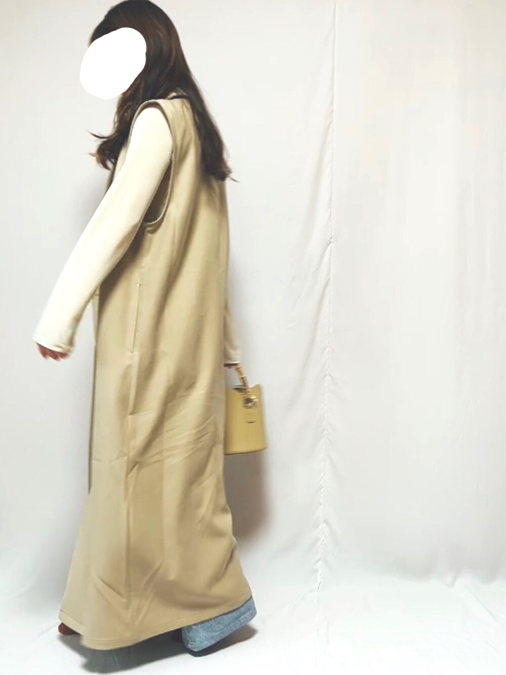 ブルー系のデニムパンツ、ベージュ系のハンドバッグ、ベージュ系のTシャツ/カットソーを着用したレディースの春コーディネートの4枚目の写真