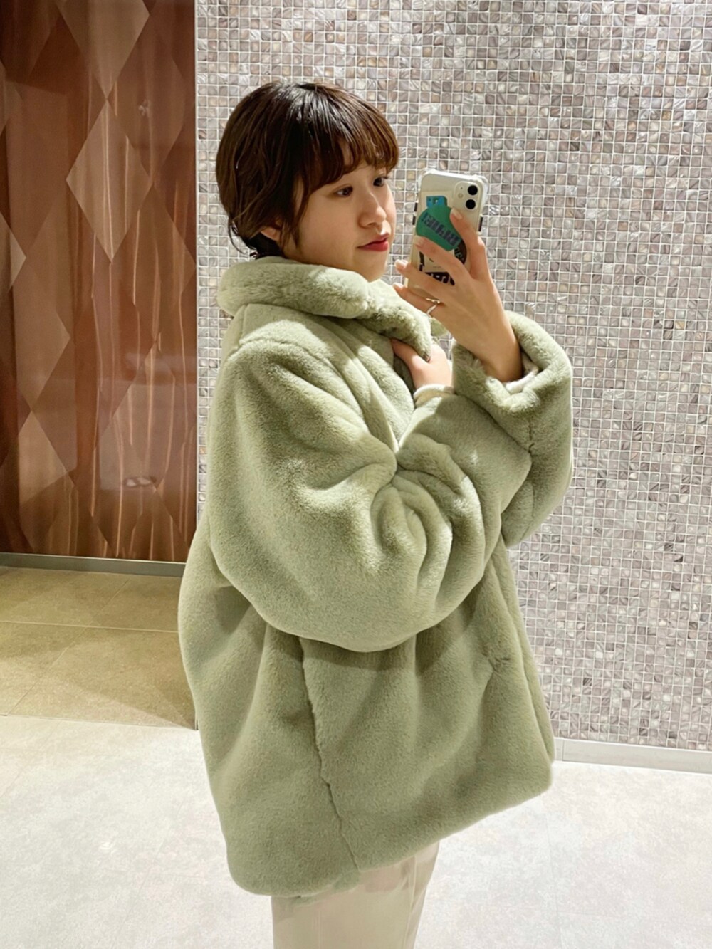 ベージュ系のデニムパンツ、グリーン系のその他アウター、ホワイト系のニット/セーターを着用したレディースの秋コーディネートの5枚目の写真