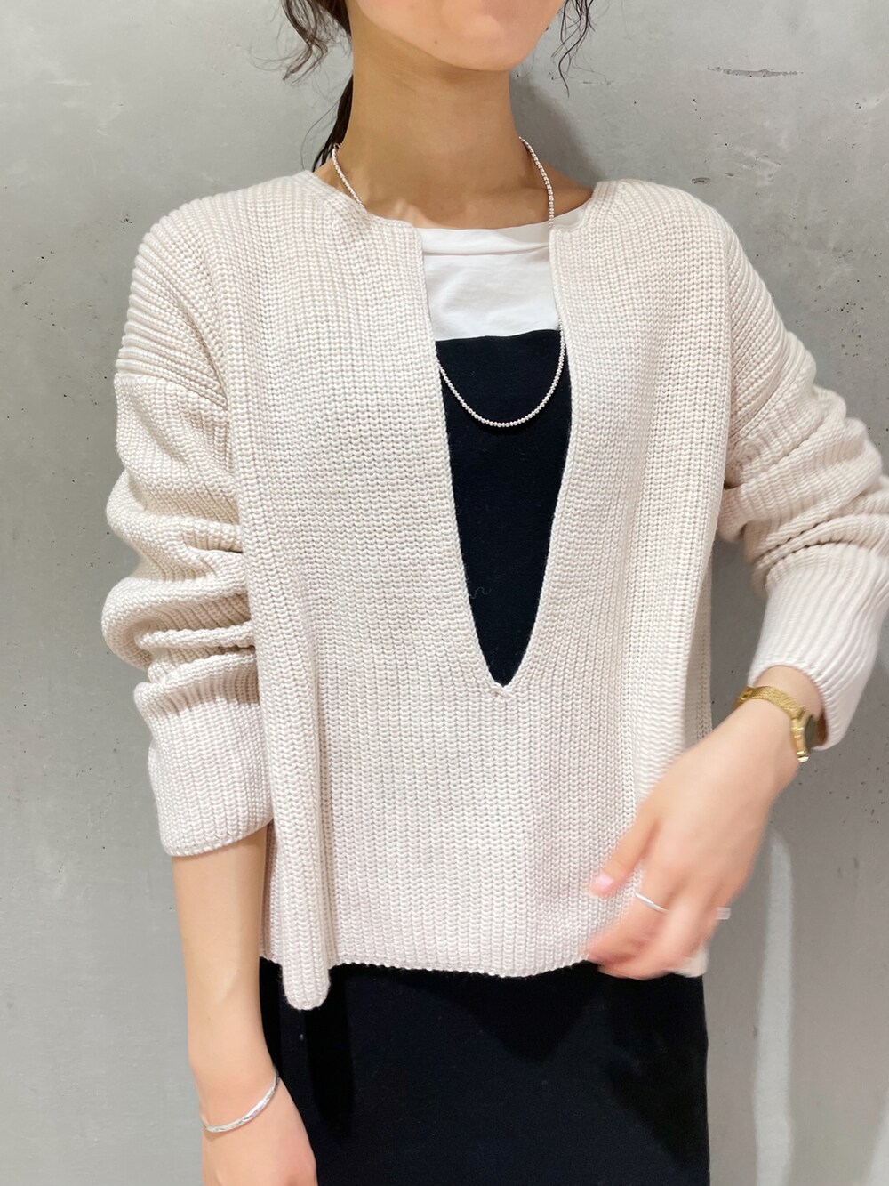 ホワイト系のニット/セーター、ブラック系のワンピース、ブラック系のブーツを着用したレディースの秋コーディネートの3枚目の写真